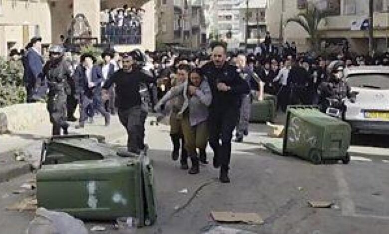 Две израелске војнике у пратњи полиције након што их је јурила насилна ултраправославна руља